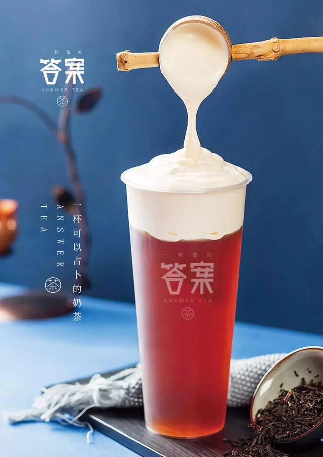 Cheese foam being ladled onto a cup of Answer Tea